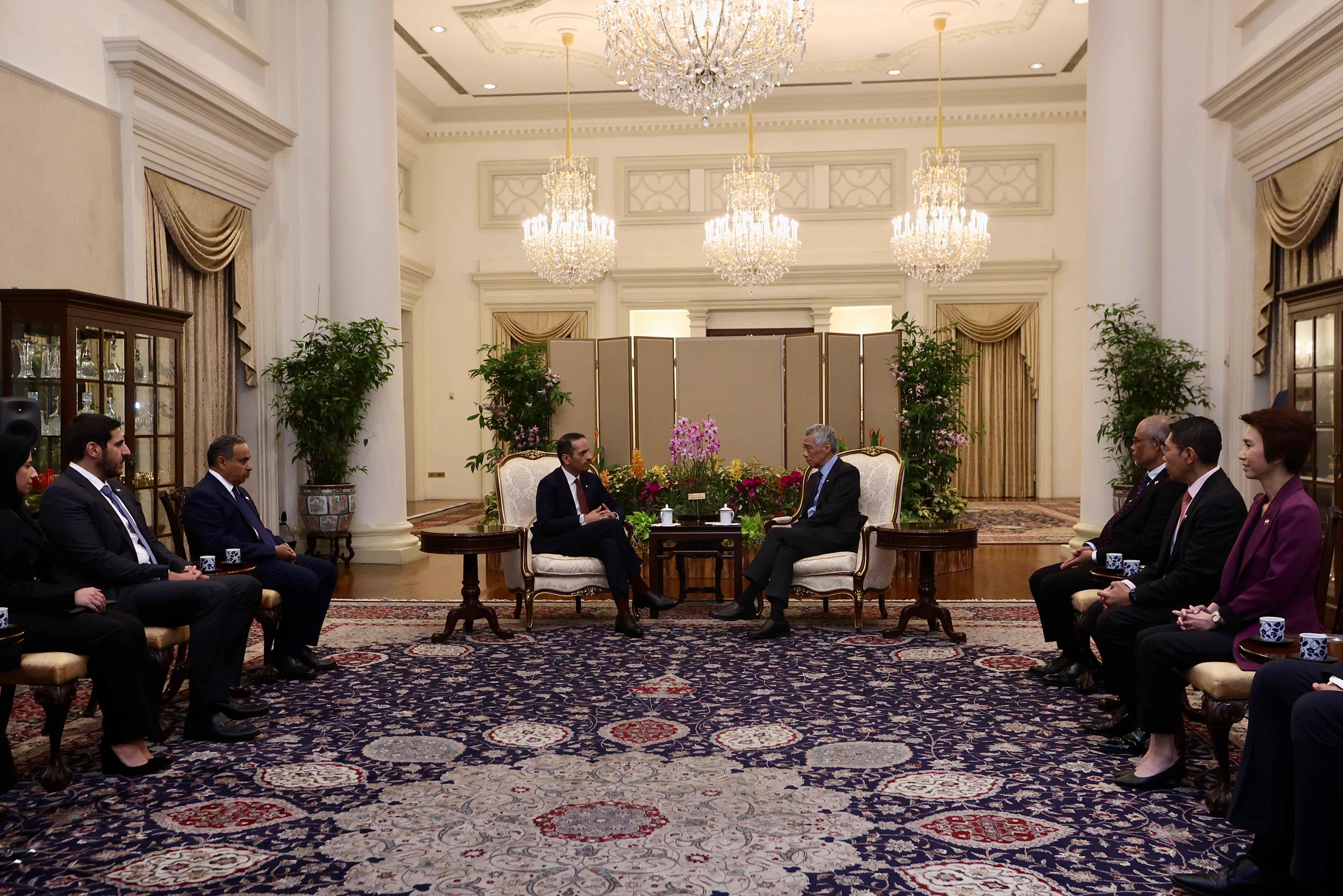 Lee Hsien Loong meeting with delegates in ornate room.