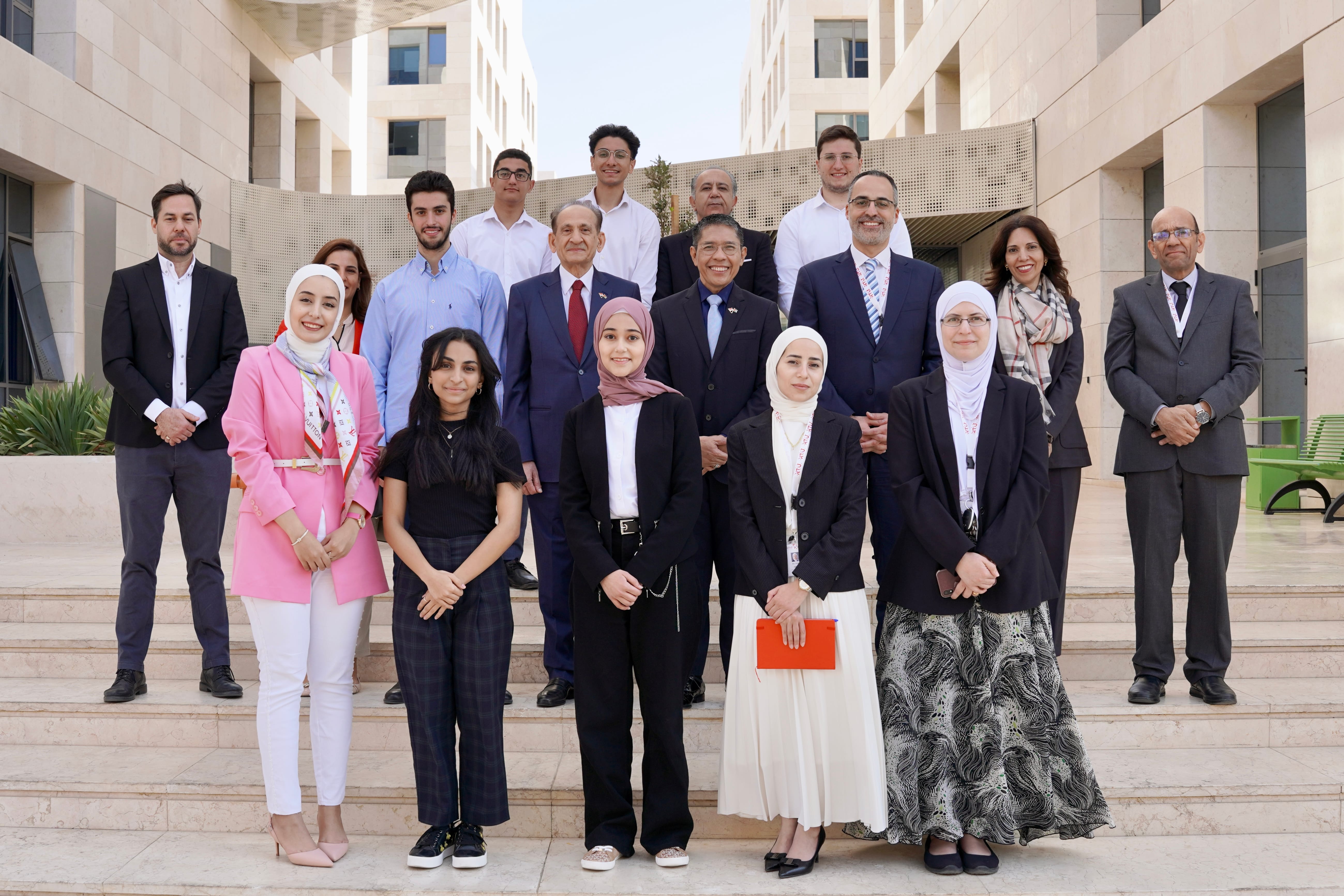 Group of people standing on steps of building.