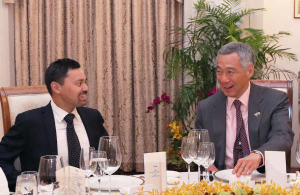 Two men in suits at formal dinner table, Lee Hsien Loong visible.
