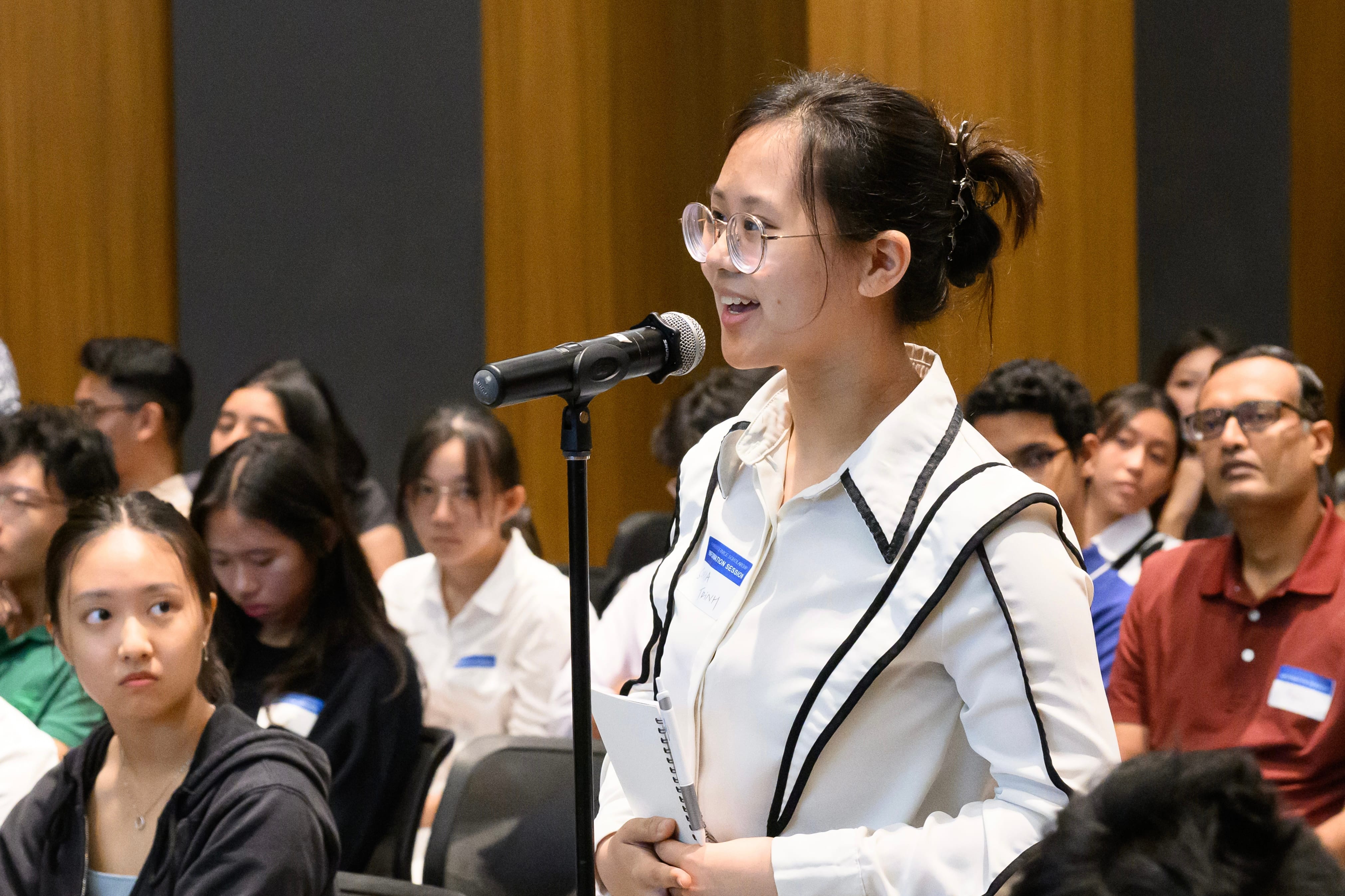 Participant asking a question at the microphone during an MFA event