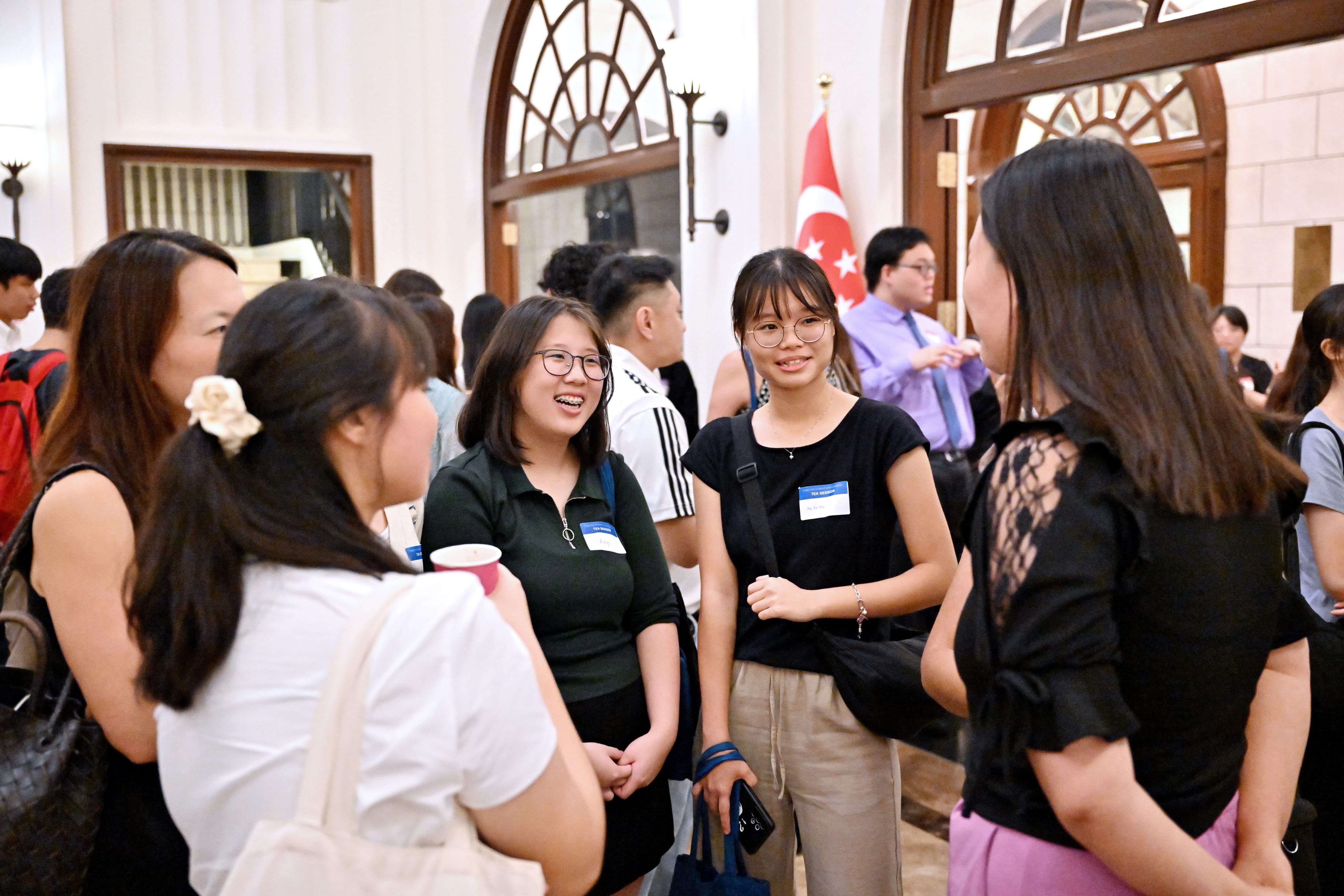 Group of young participants chatting and smiling at the scholarship networking session