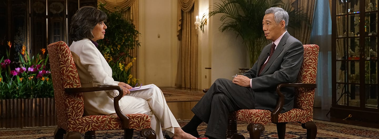 Christiane Amanpour interviewing Lee Hsien Loong, both seated in patterned armchairs.