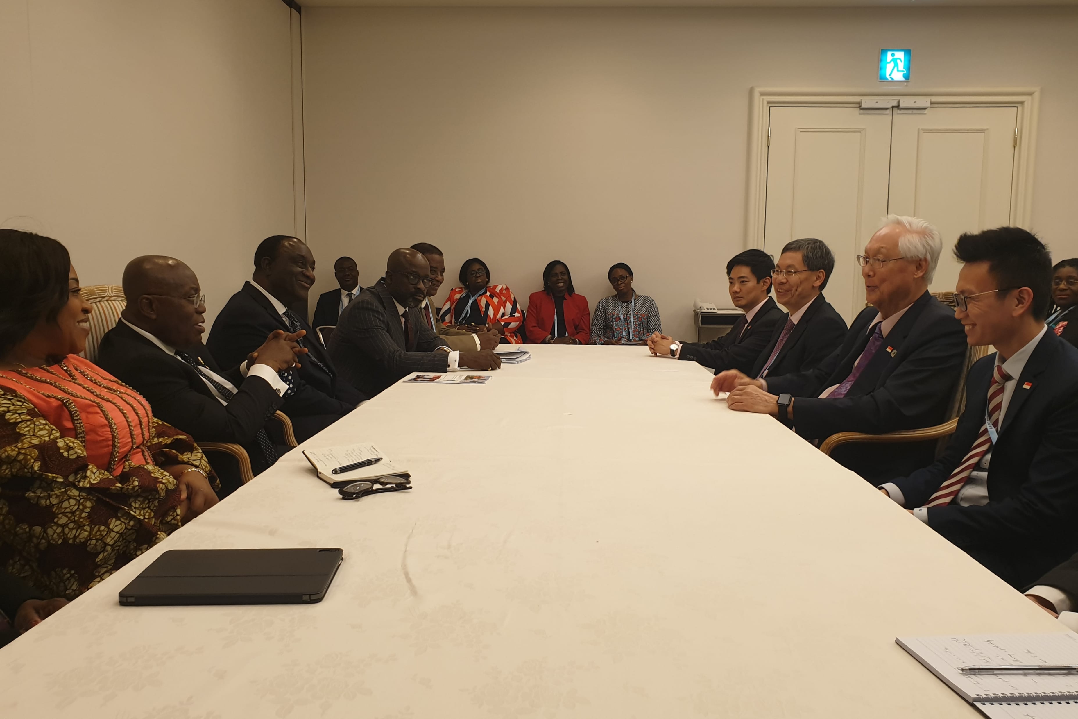 Meeting with two groups of people seated at a large table.