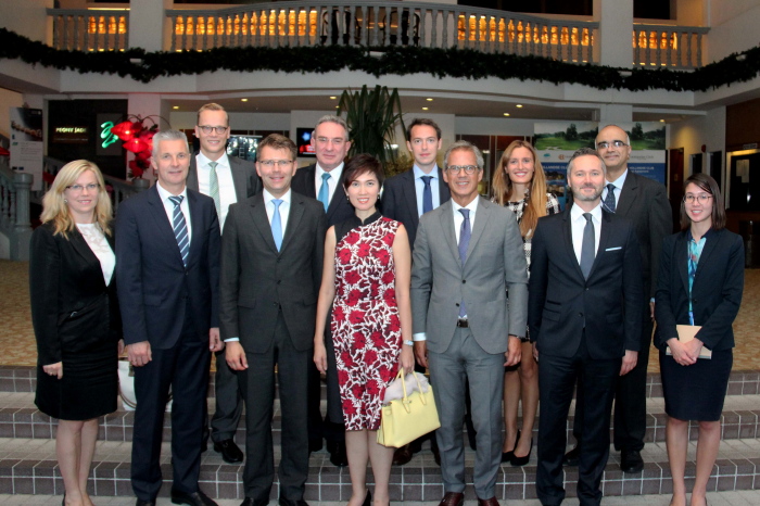 Group of people in business attire posing on stairs in front of a decorated balcony.