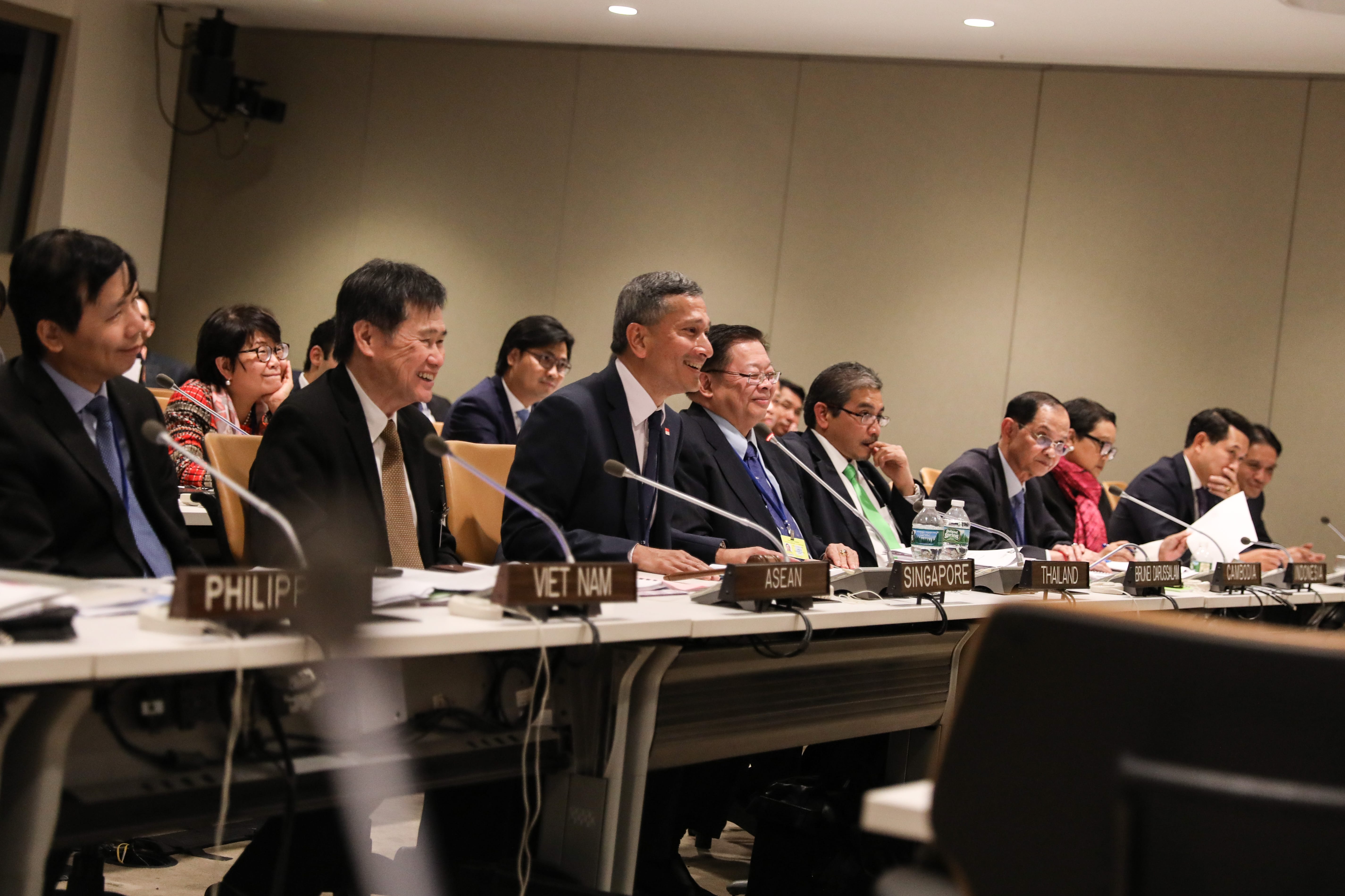 Delegates at a long table with some ASEAN countries nameplates.