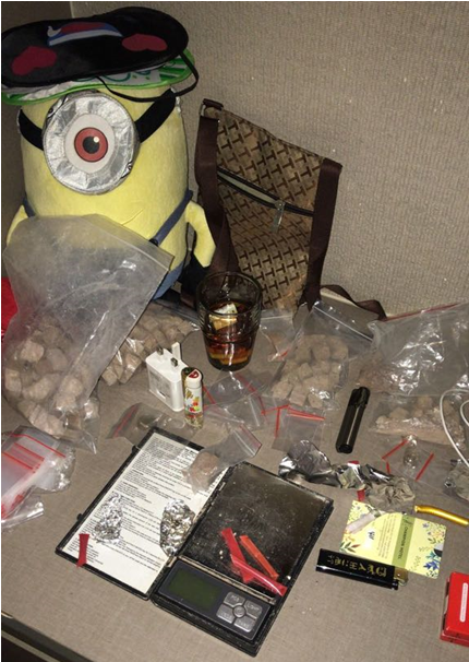Minion plush with sleep mask, brown patterned bag, scale, baggies, drink, and paraphernalia.
