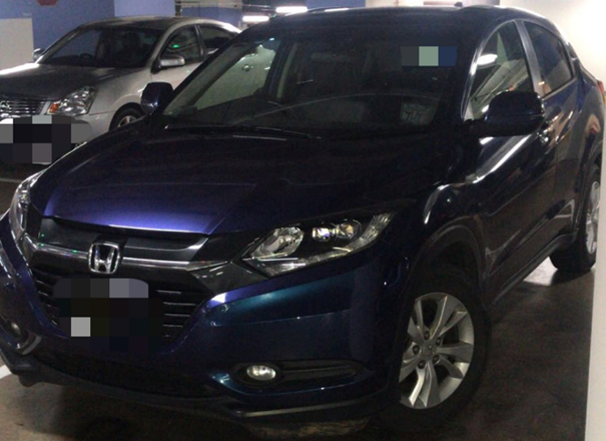 Dark blue Honda HRV parked in a parking garage, with a silver car behind.