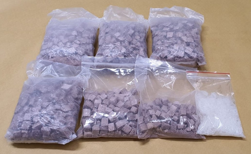 Seven plastic bags: six with brown cubes, one with white crystals.