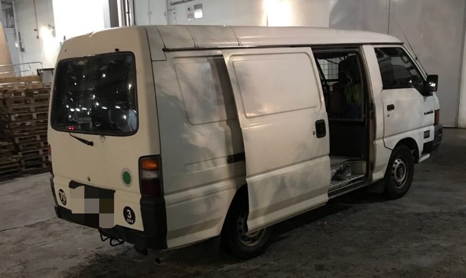 White Mitsubishi van with open side and rear doors, parked indoors.