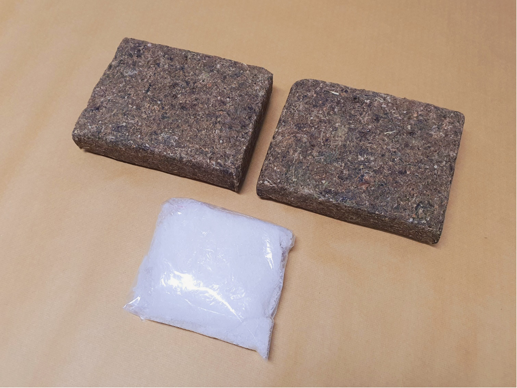 Two rough brown bricks and a clear plastic bag with white material on a tan surface.
