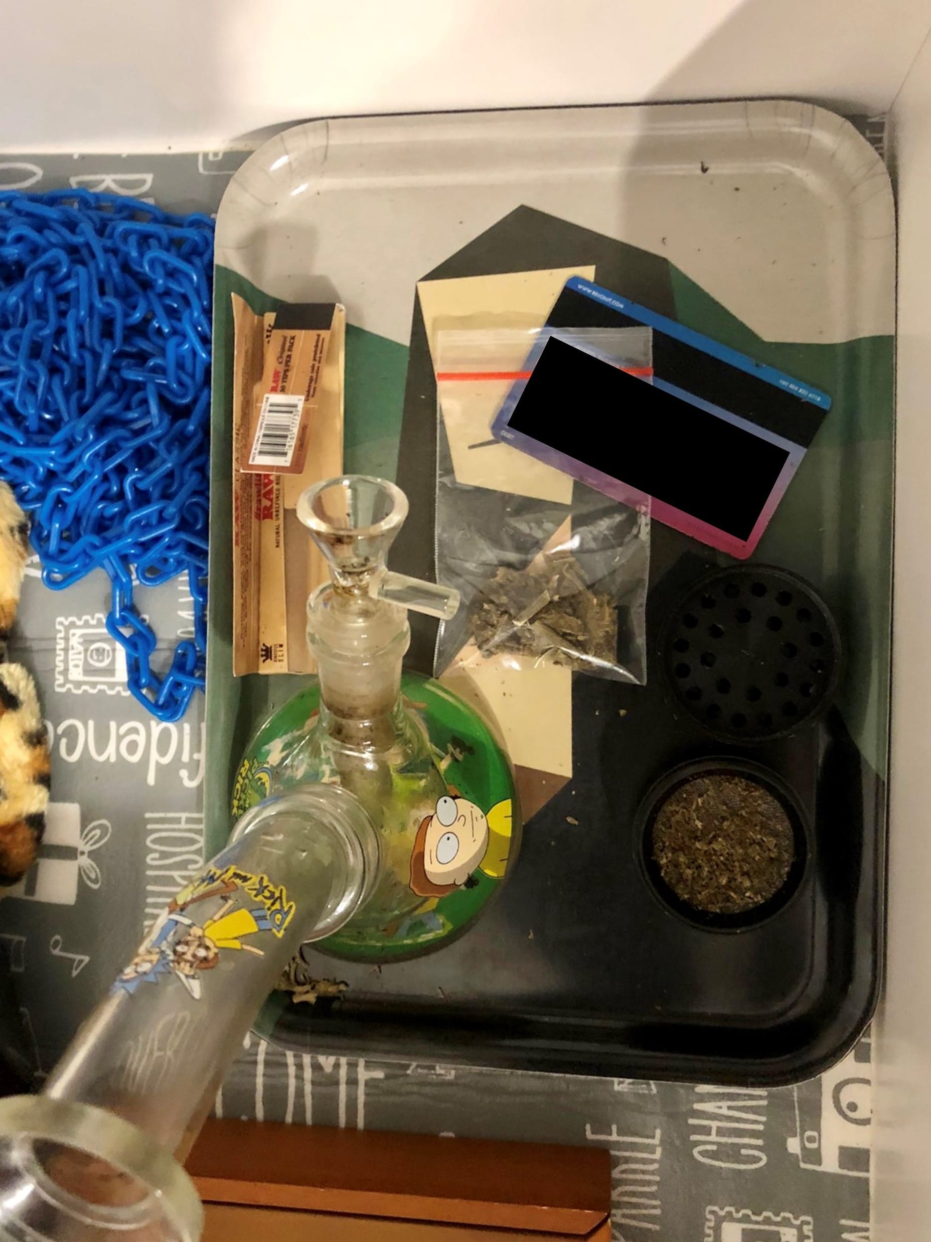 Rick & Morty themed bong and tray with grinder, RAW papers, and card with blocked info.