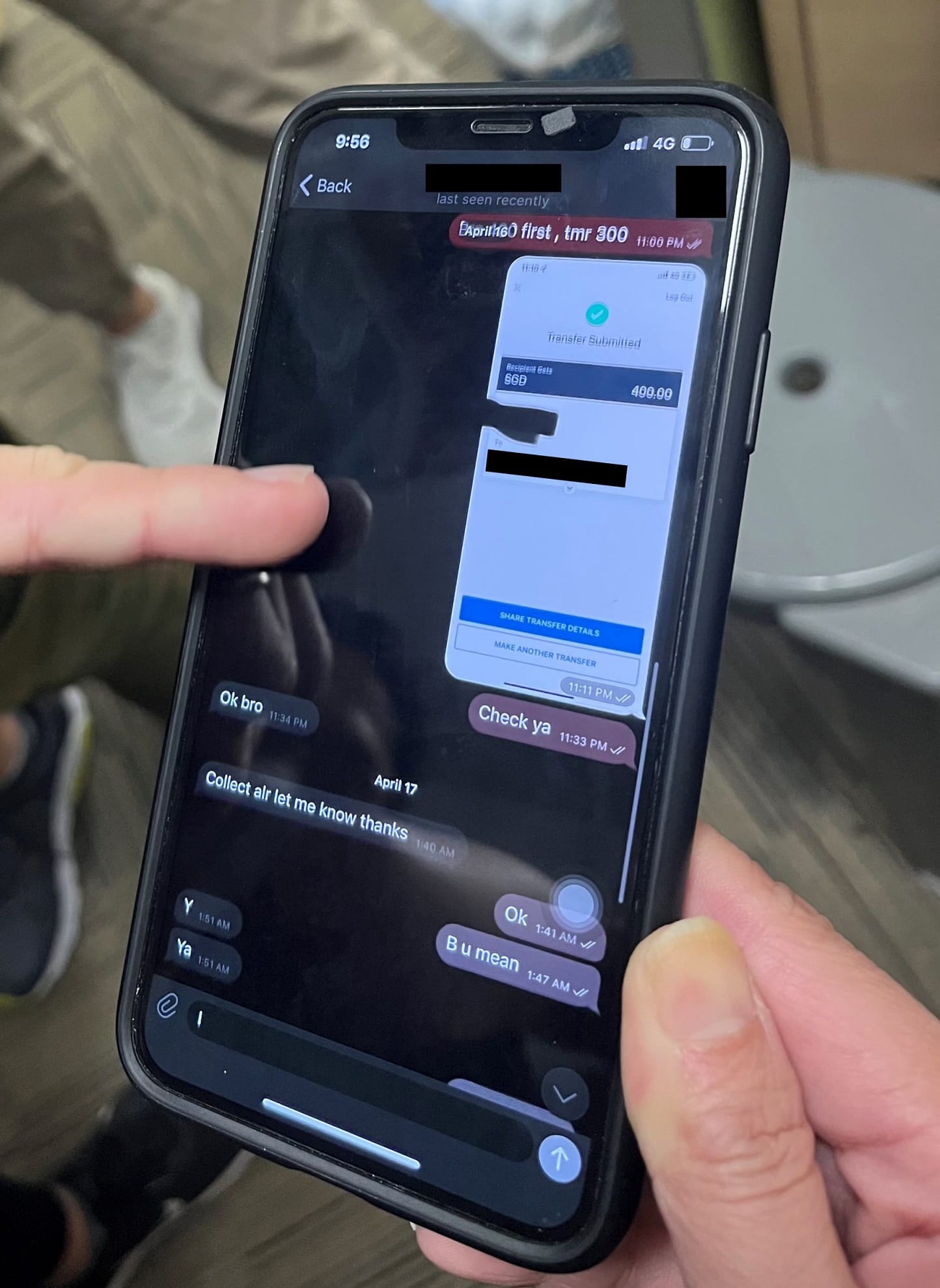 Person holds iPhone displaying a messaging app, featuring a transfer submission.