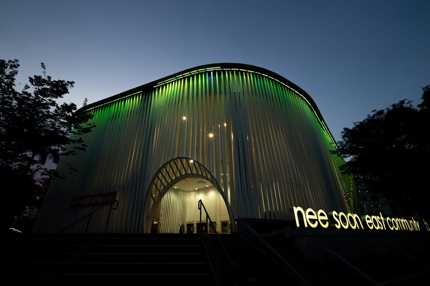 Nee Soon East Community building with green lighting, viewed from stairs at dusk.