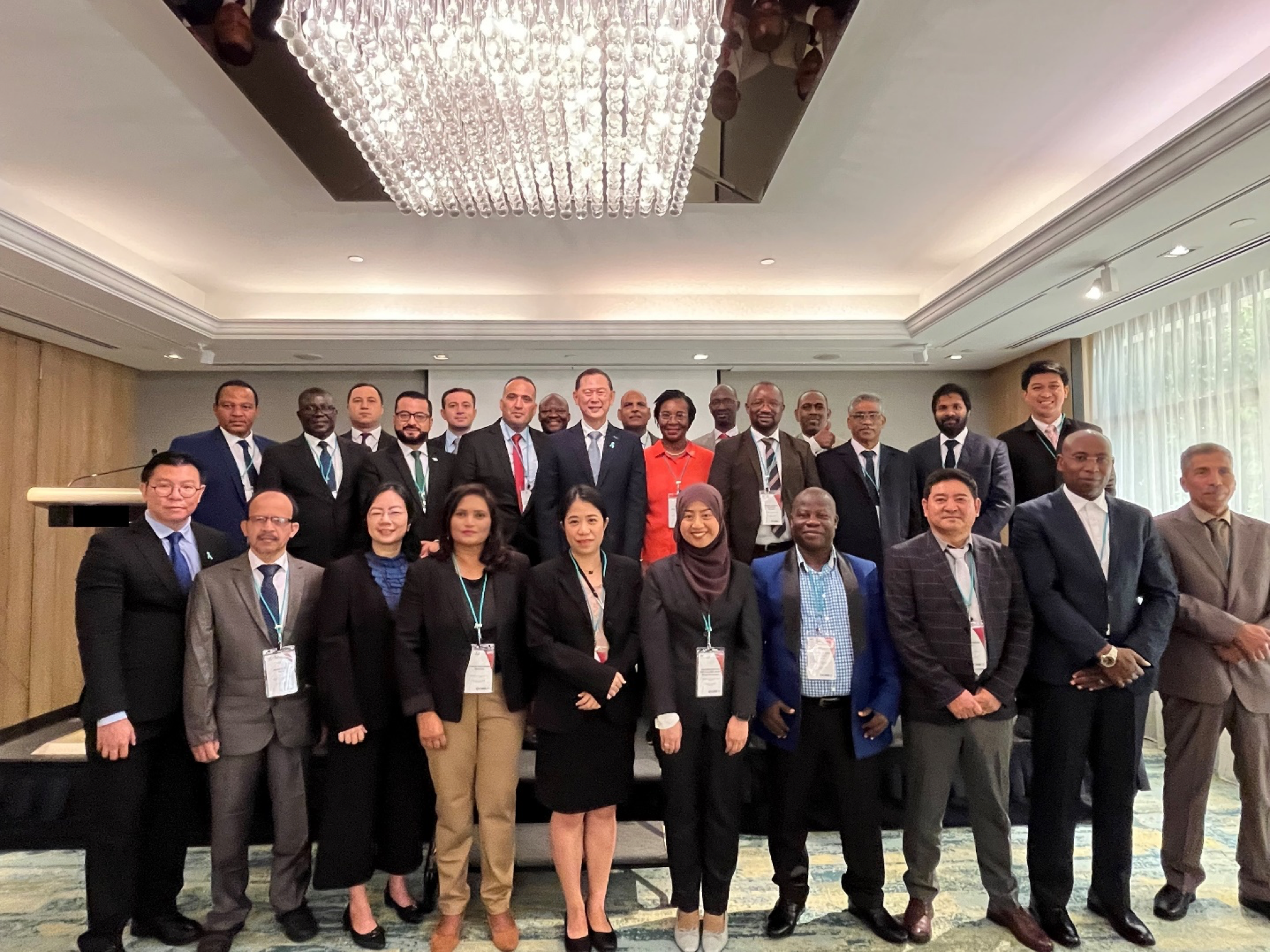 Group of diverse professionals in business attire posing for a photo indoors.