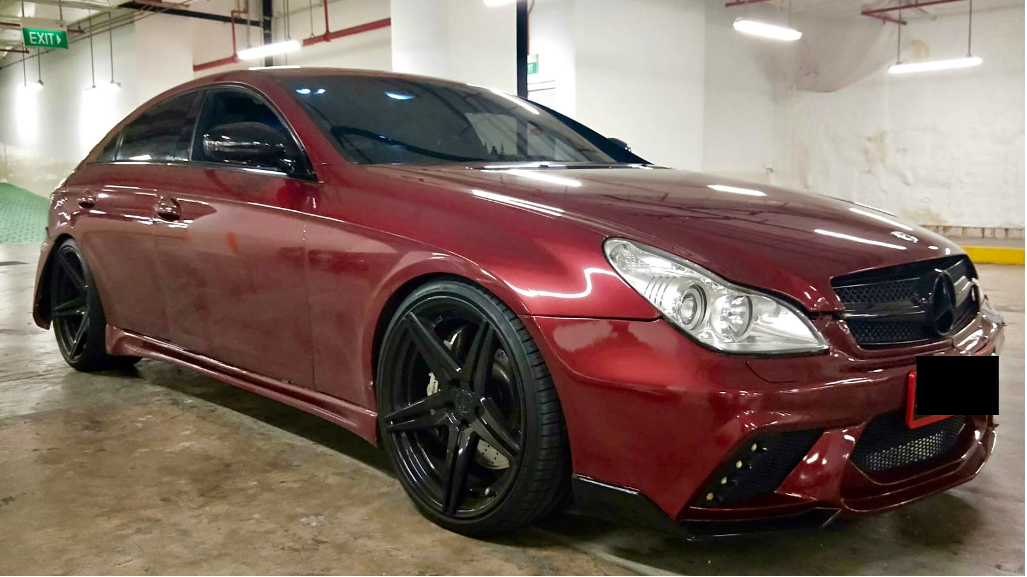 Maroon Mercedes-Benz coupe with black rims parked in an indoor garage.