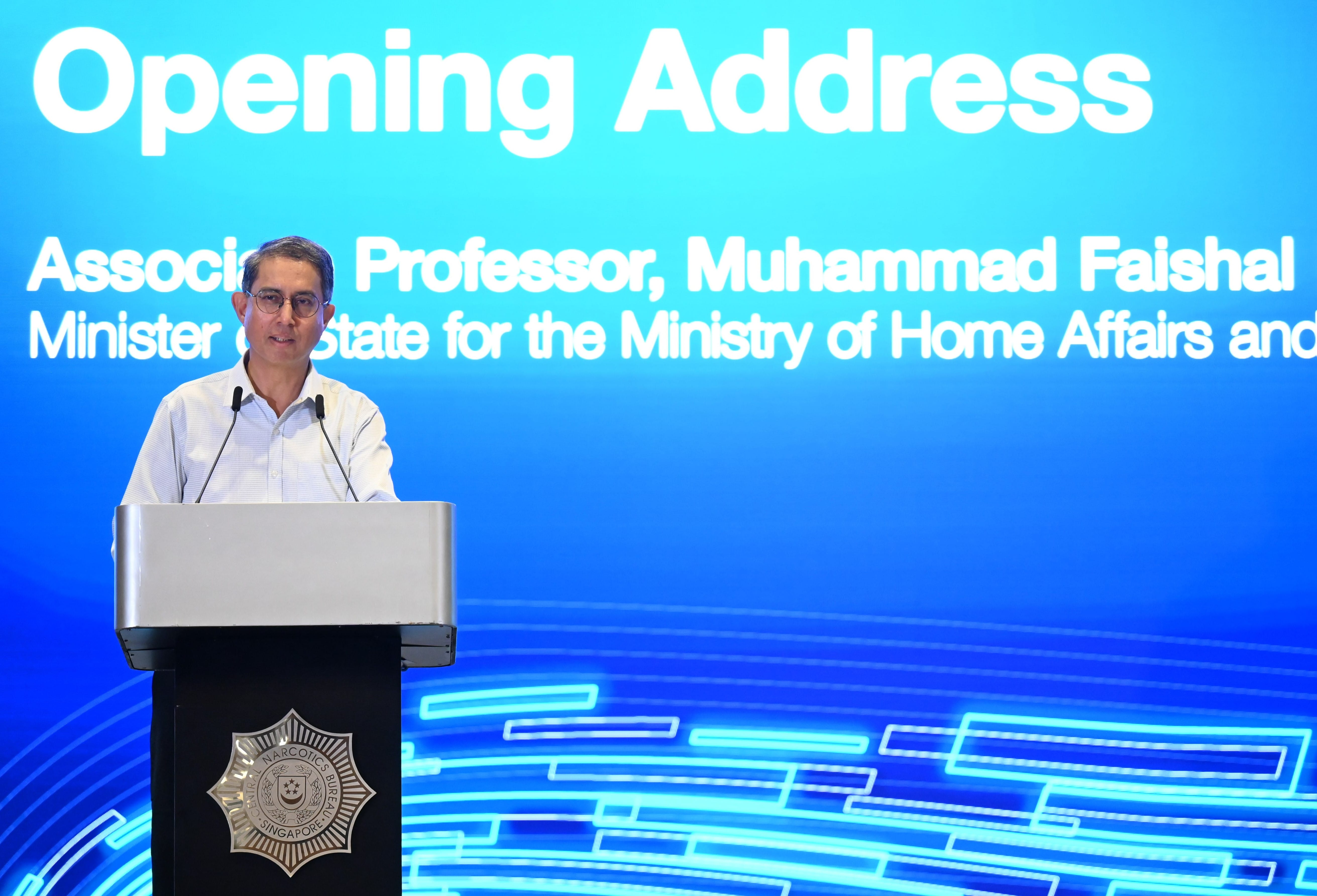 Man at podium with seal of "Central Narcotics Bureau Singapore" before "Opening Address" text.