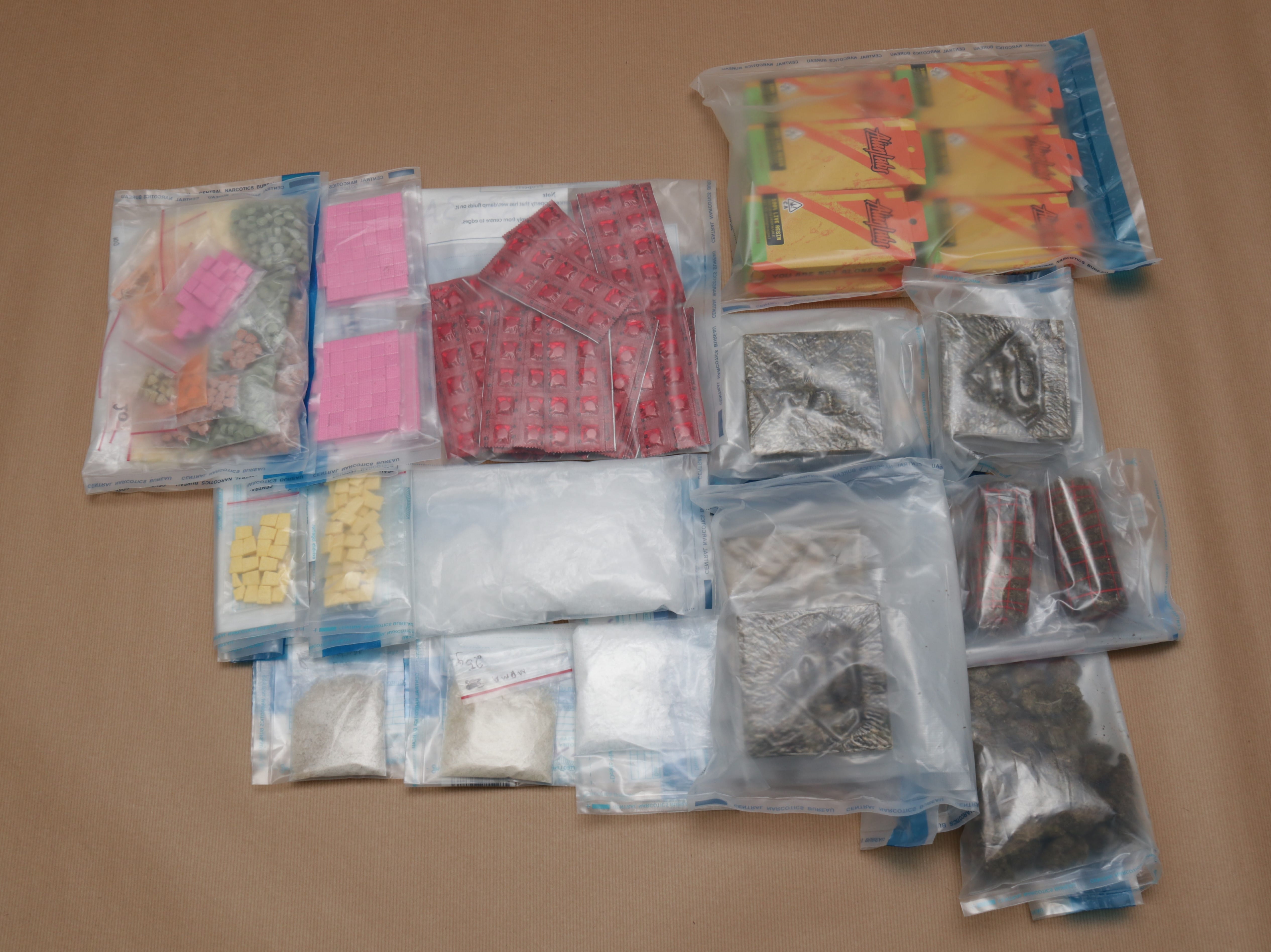 Various drugs in clear bags, including tablets, white powder, Almalfi carts, and marijuana.