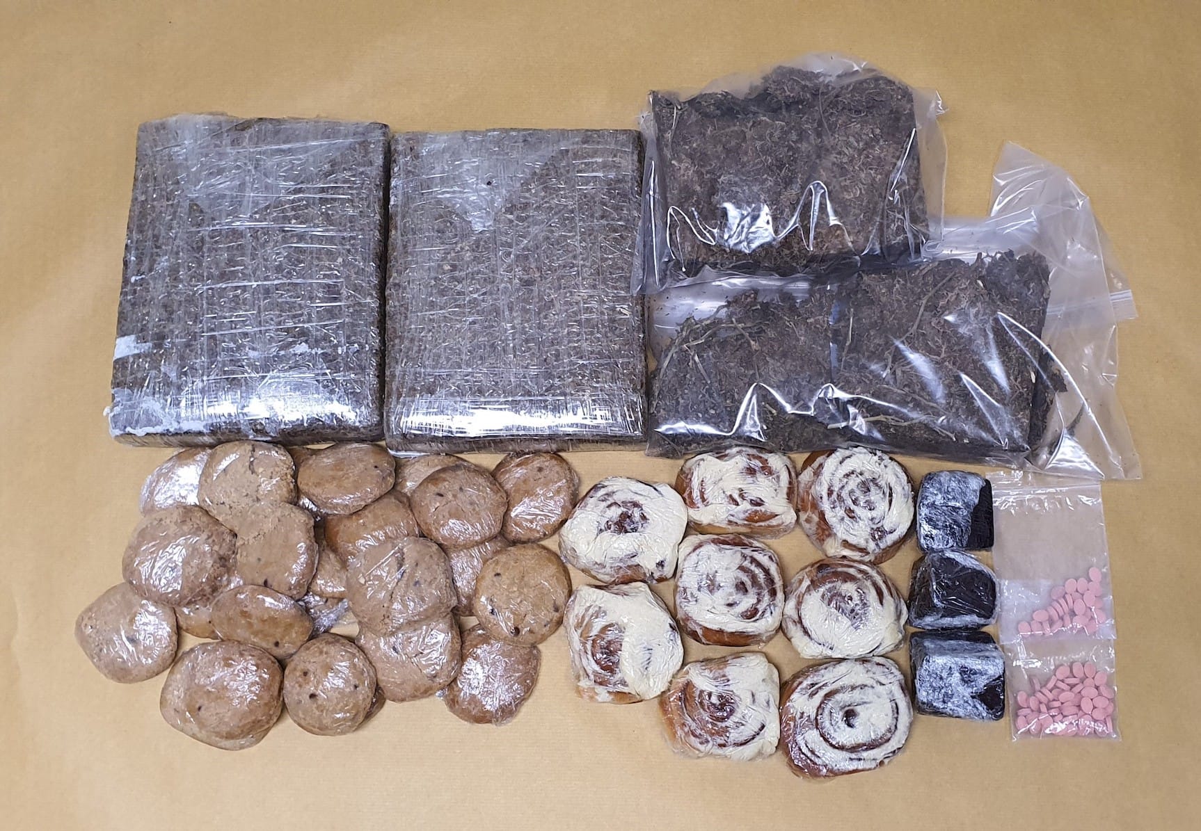 White bin holds plastic bag of white crystals, orange spoon, metal spoon, and orange-handled saw.