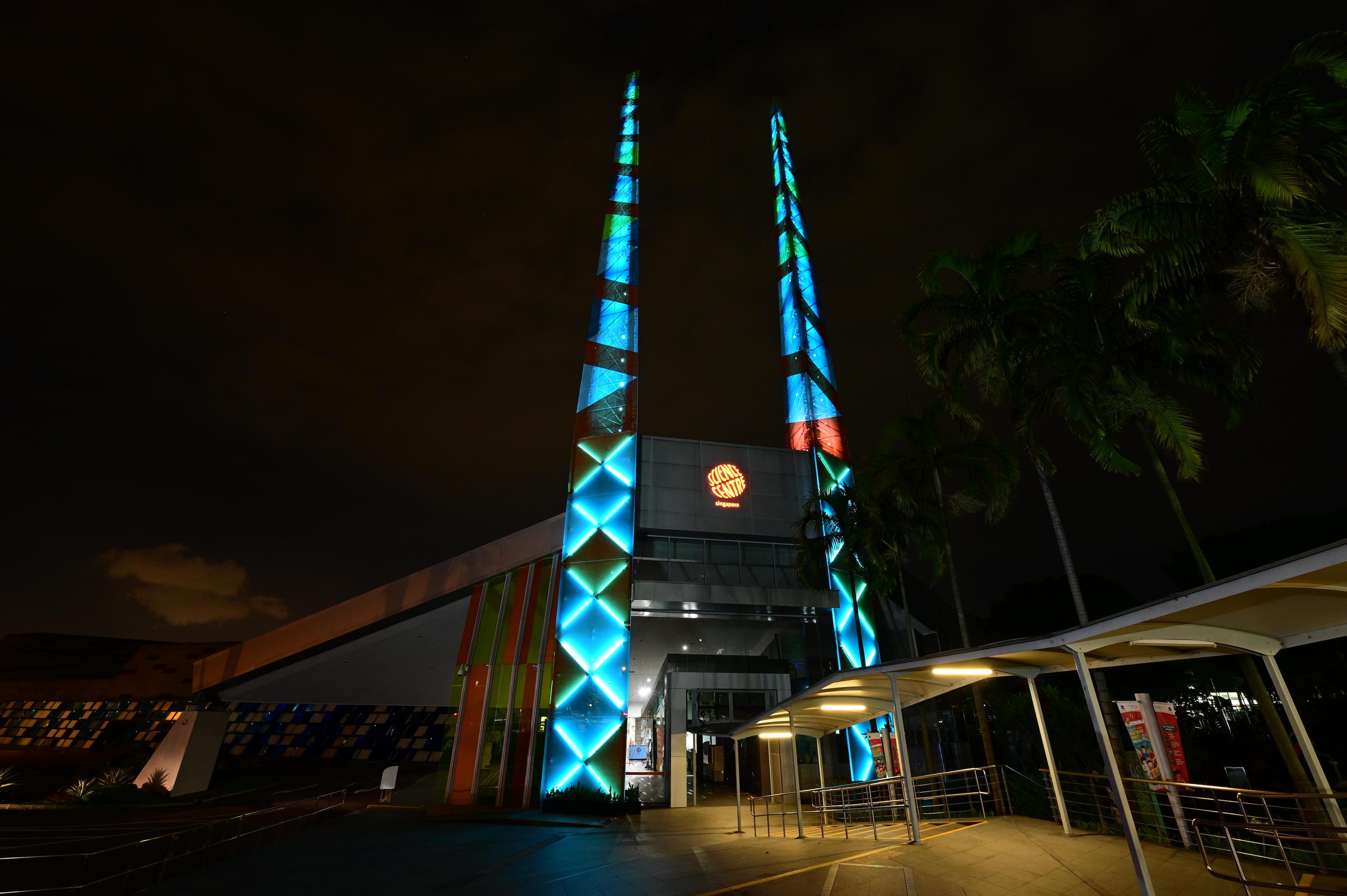 Science Centre Singapore building at night with tall lit geometric towers.