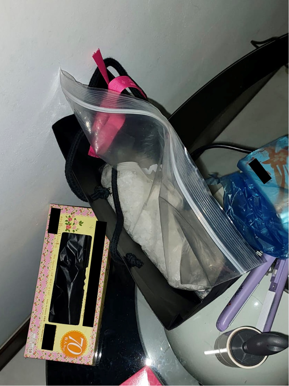 Assorted items including a floral tissue box and plastic bag with contents on a table.