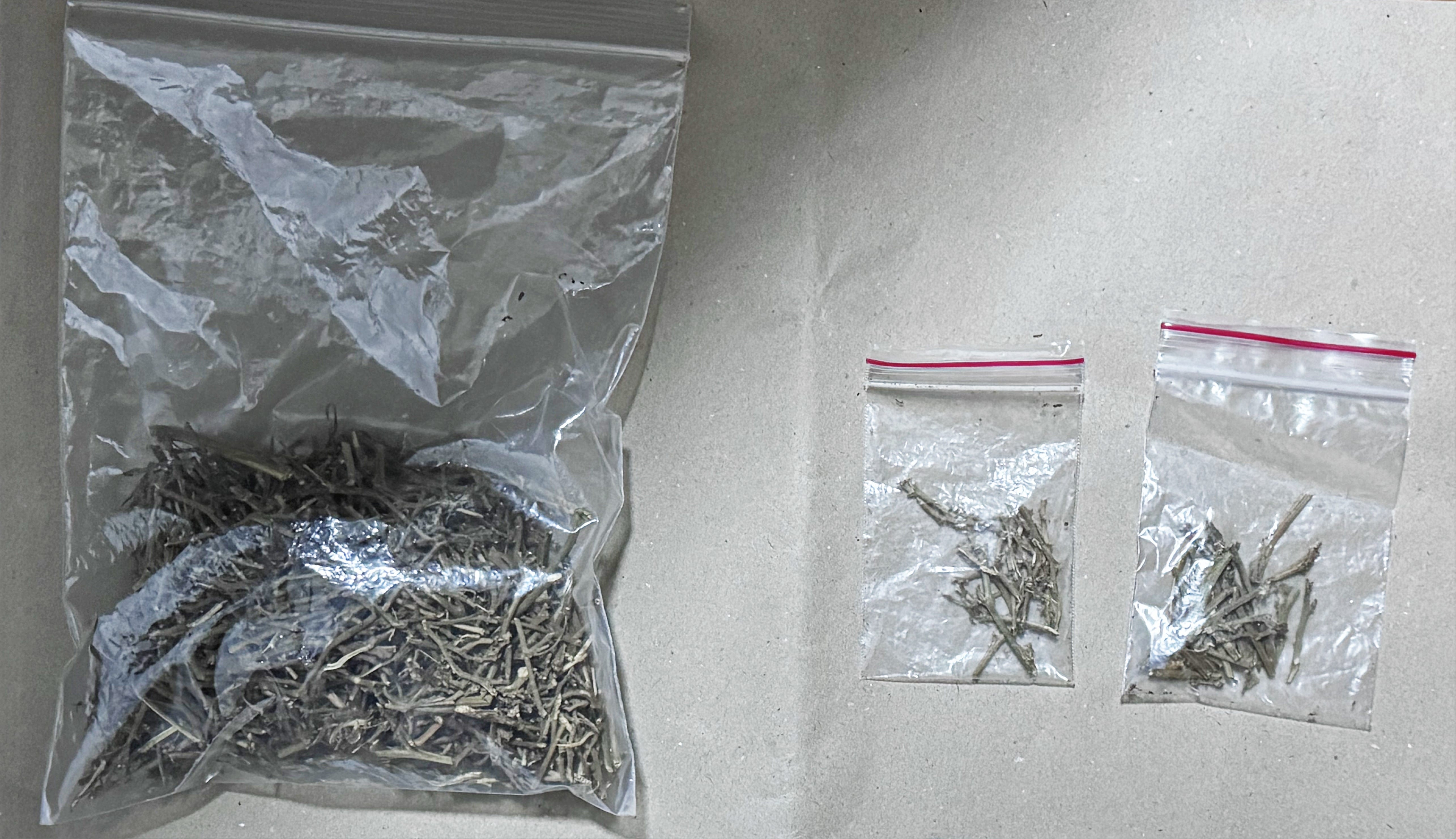Three clear plastic bags containing dried herbs or spices on a gray surface.