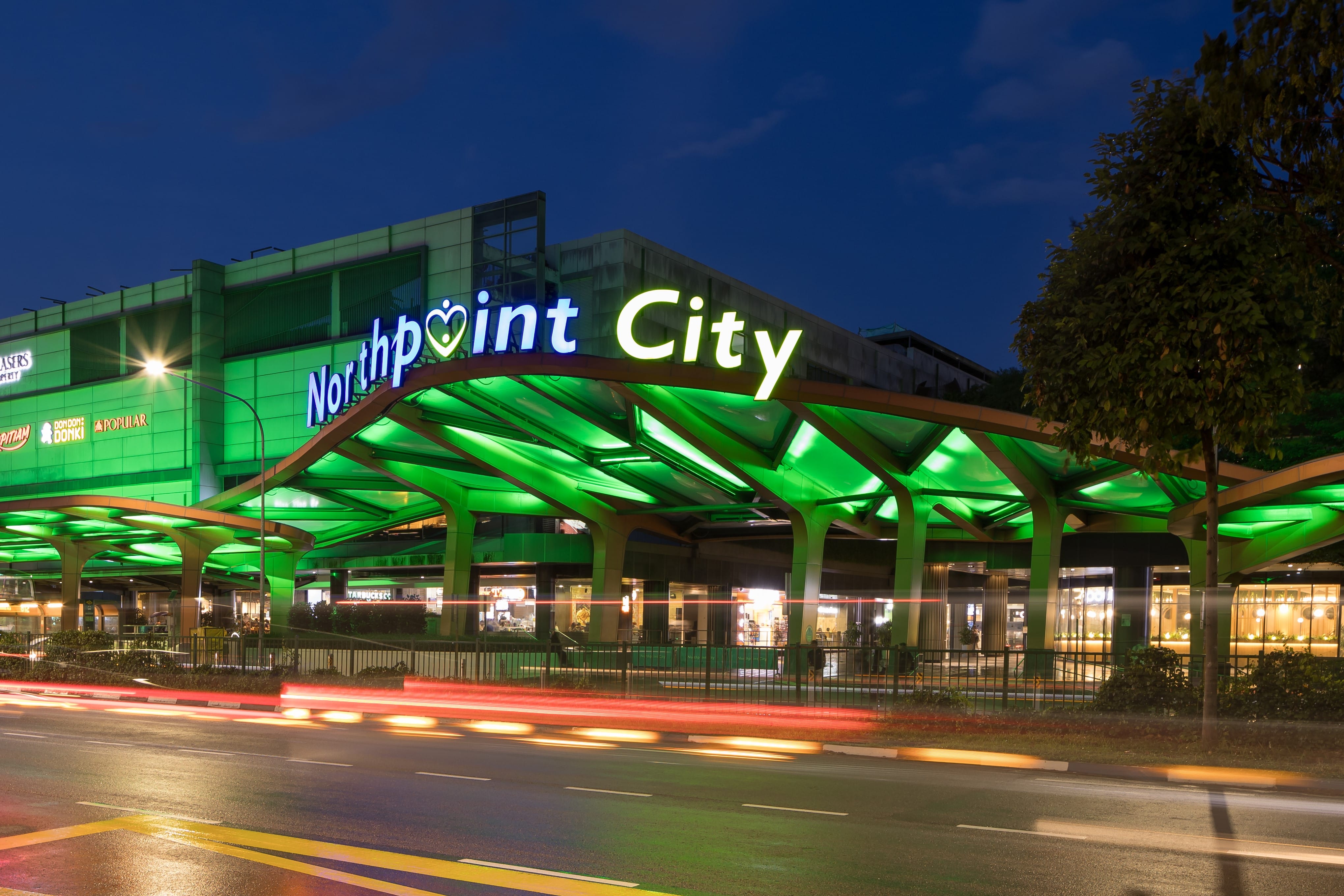 Northpoint City building facade at dusk with blurred vehicle light trails.