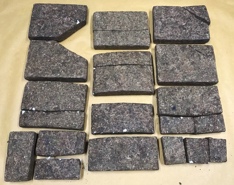 Several dark brown pressed blocks arranged on a tan surface.