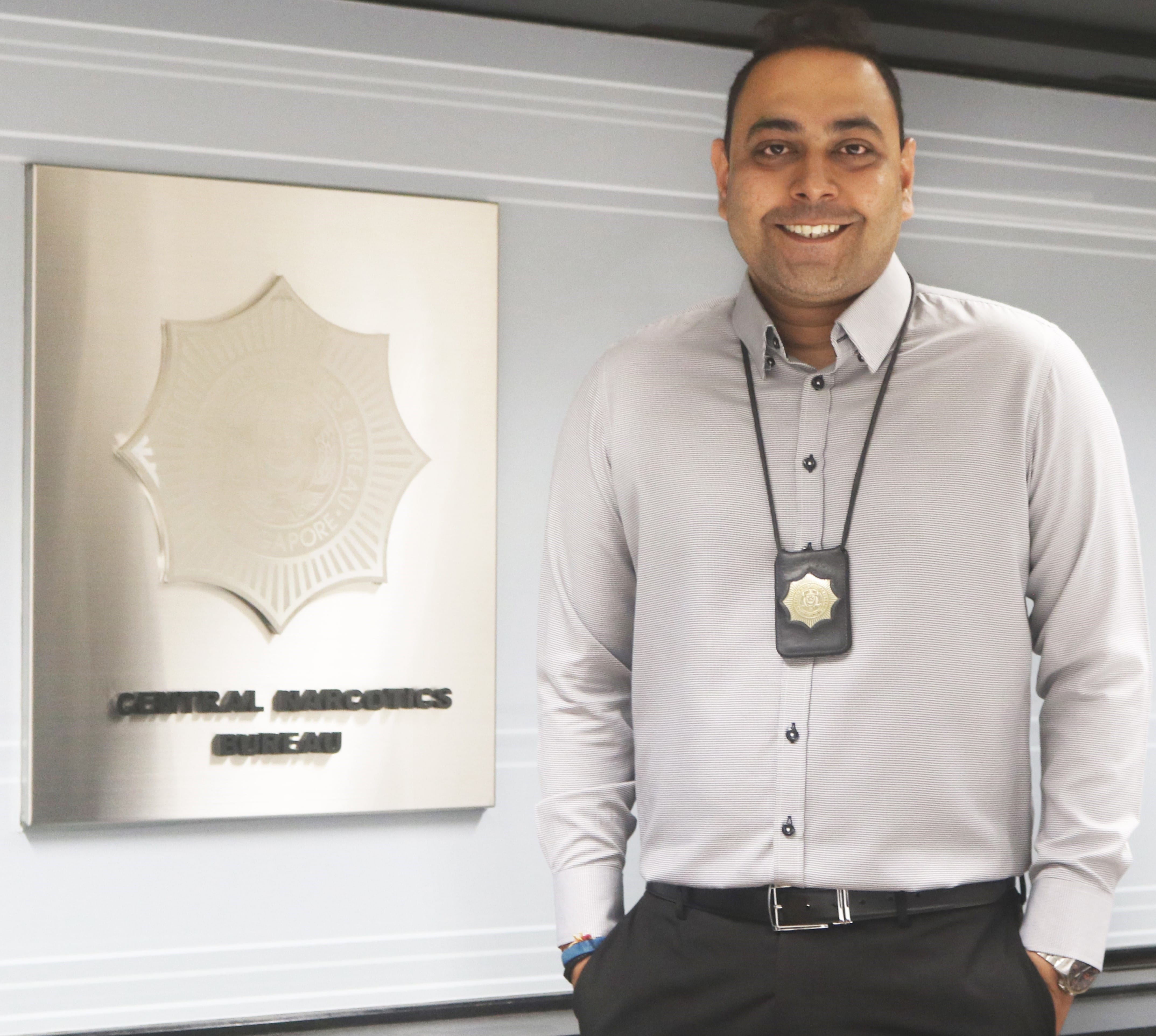 Dinesh Kumar Rai standing next to CNB signage.