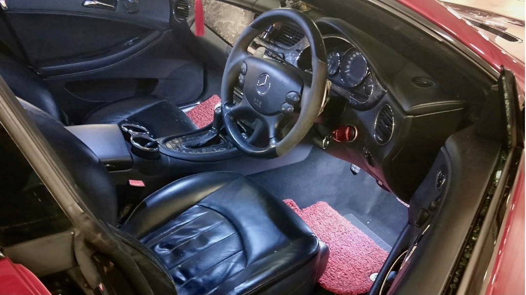 Mercedes-Benz car interior featuring black leather seats and dashboard.
