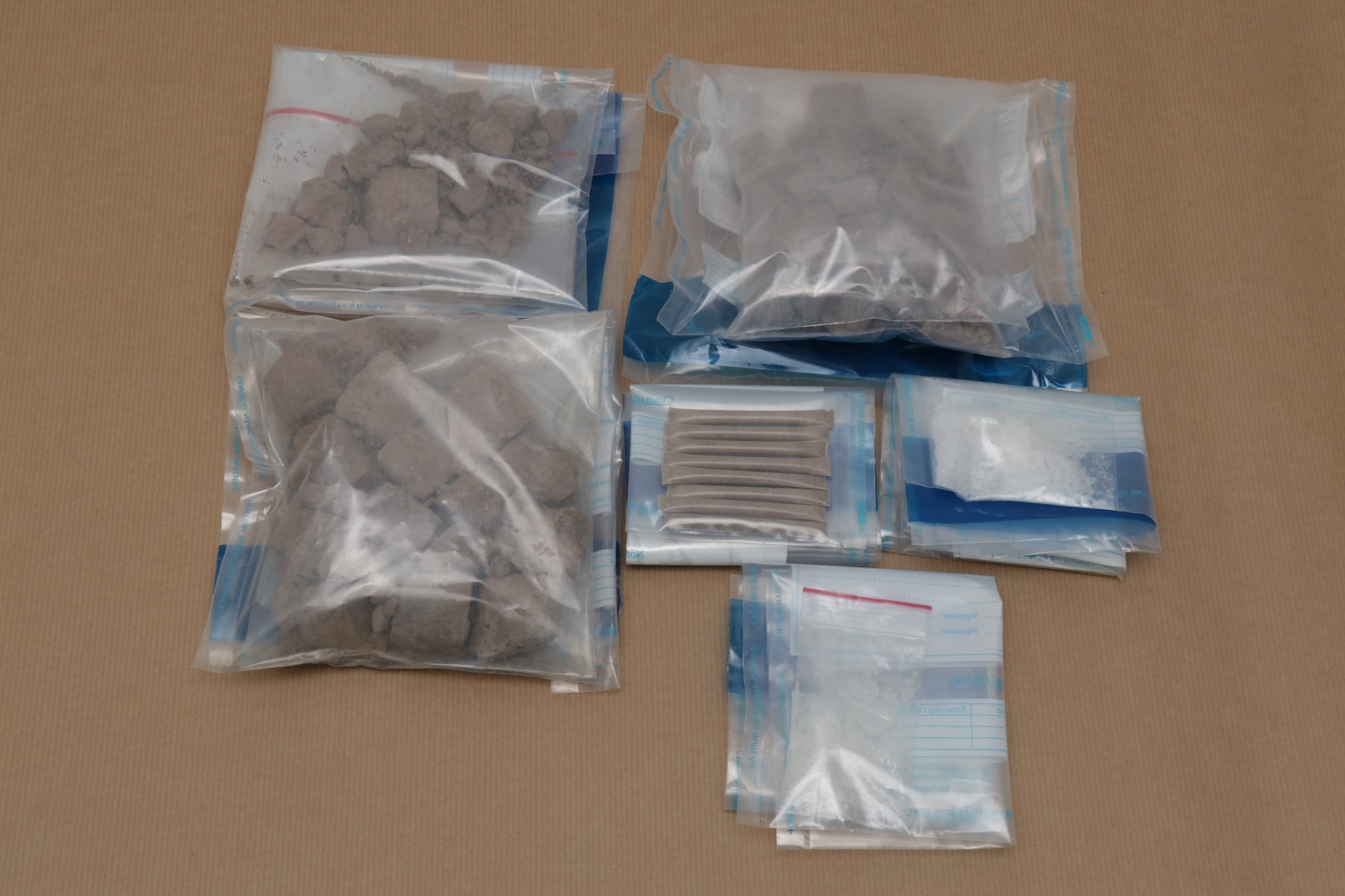 Bags of powdered and solid materials on a tan surface.