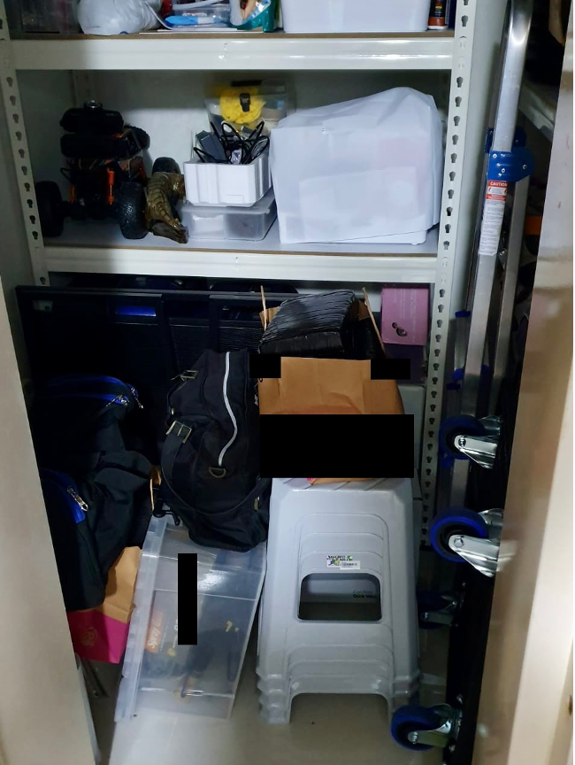 Shelving unit filled with assorted items, including a ladder, containers, and bags.