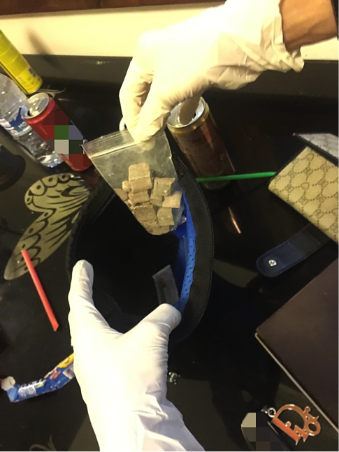 Car trunk with a spare tire cover, tools, a Heron Foods plastic bag, and a shoe.