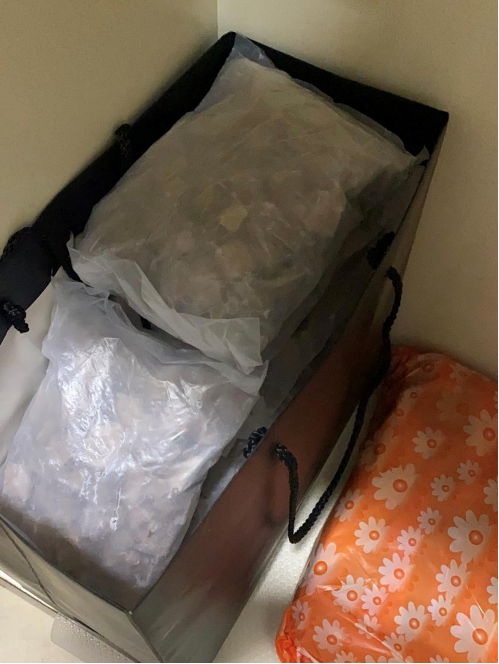 Gift bag with clear plastic bags inside. An orange floral-patterned bag is beside it.