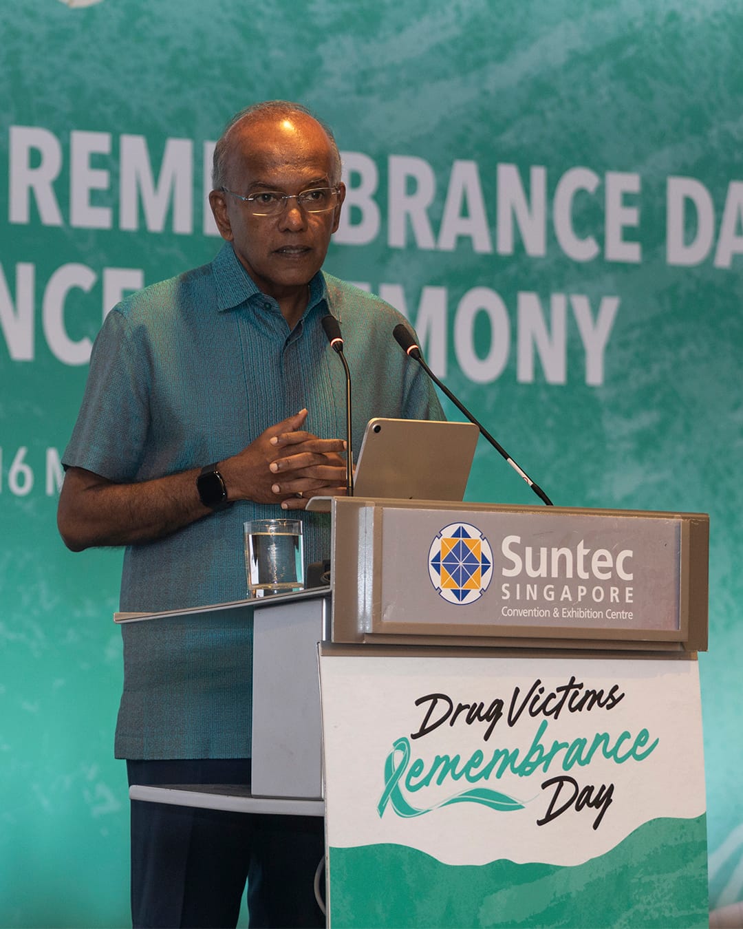 Minister speaking at a podium during Drug Victims Remembrance Day at Suntec Singapore.