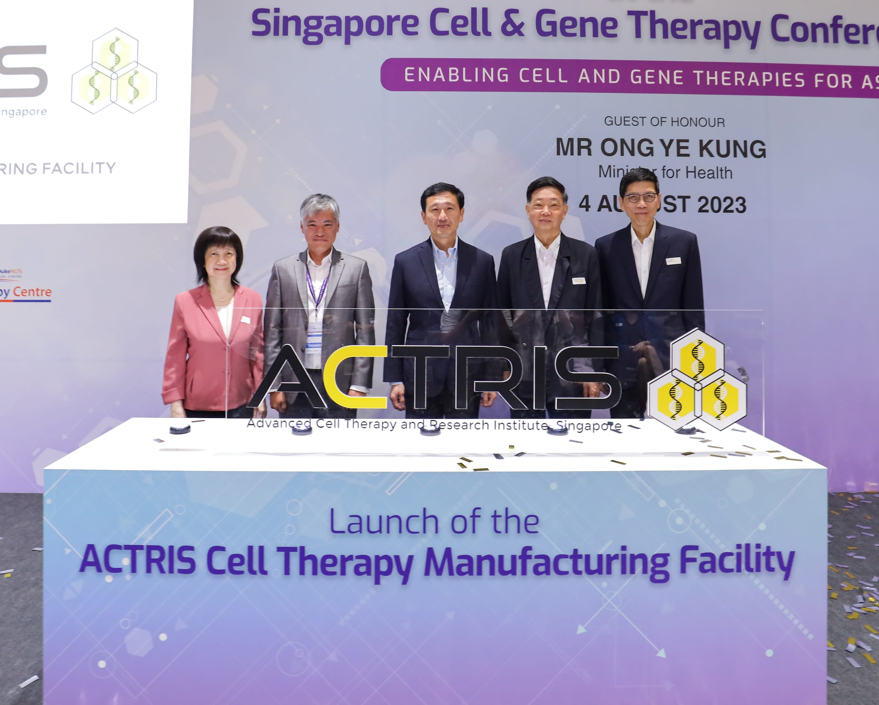 Five people standing behind a table at the launch of the ACTRIS Cell Therapy Manufacturing Facility in Singapore.