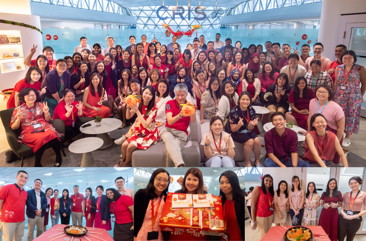 A large group of people wearing red and standing in front of a decorated office space.