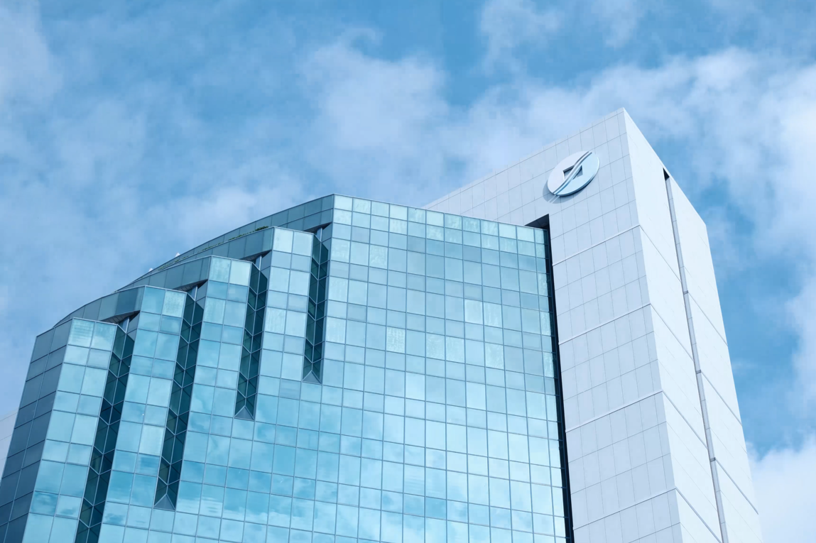 Exterior view of ACRA office building with glass facade against blue sky.