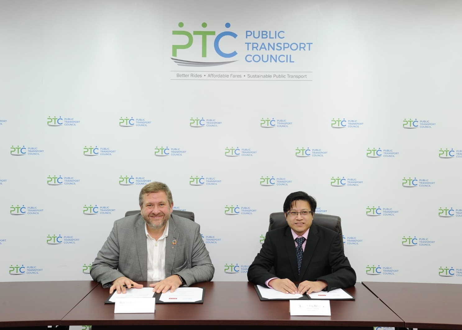 Two representatives signing a partnership agreement at the PTC office.