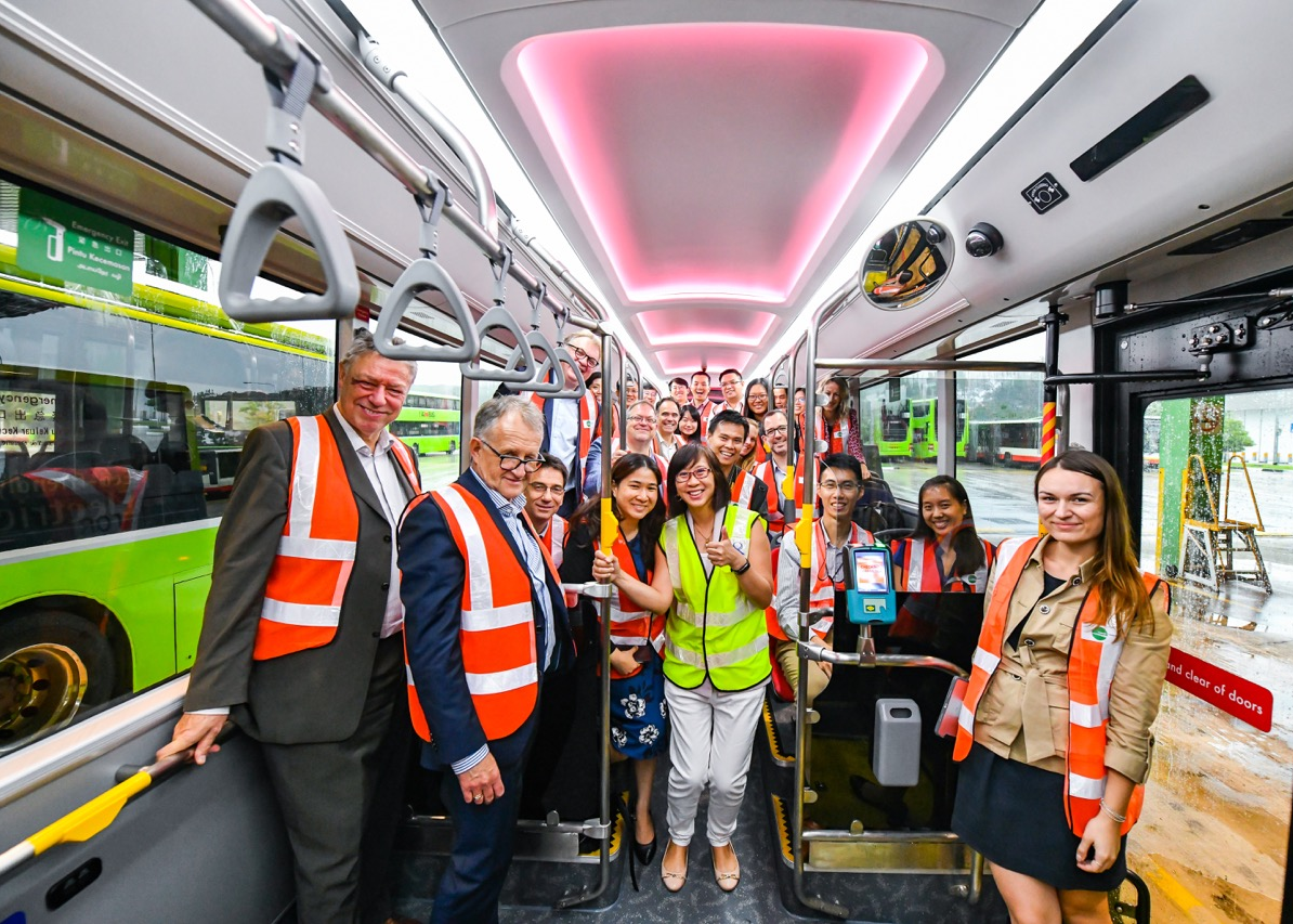 Delegates touring a bus with interior lighting during a transport site visit.