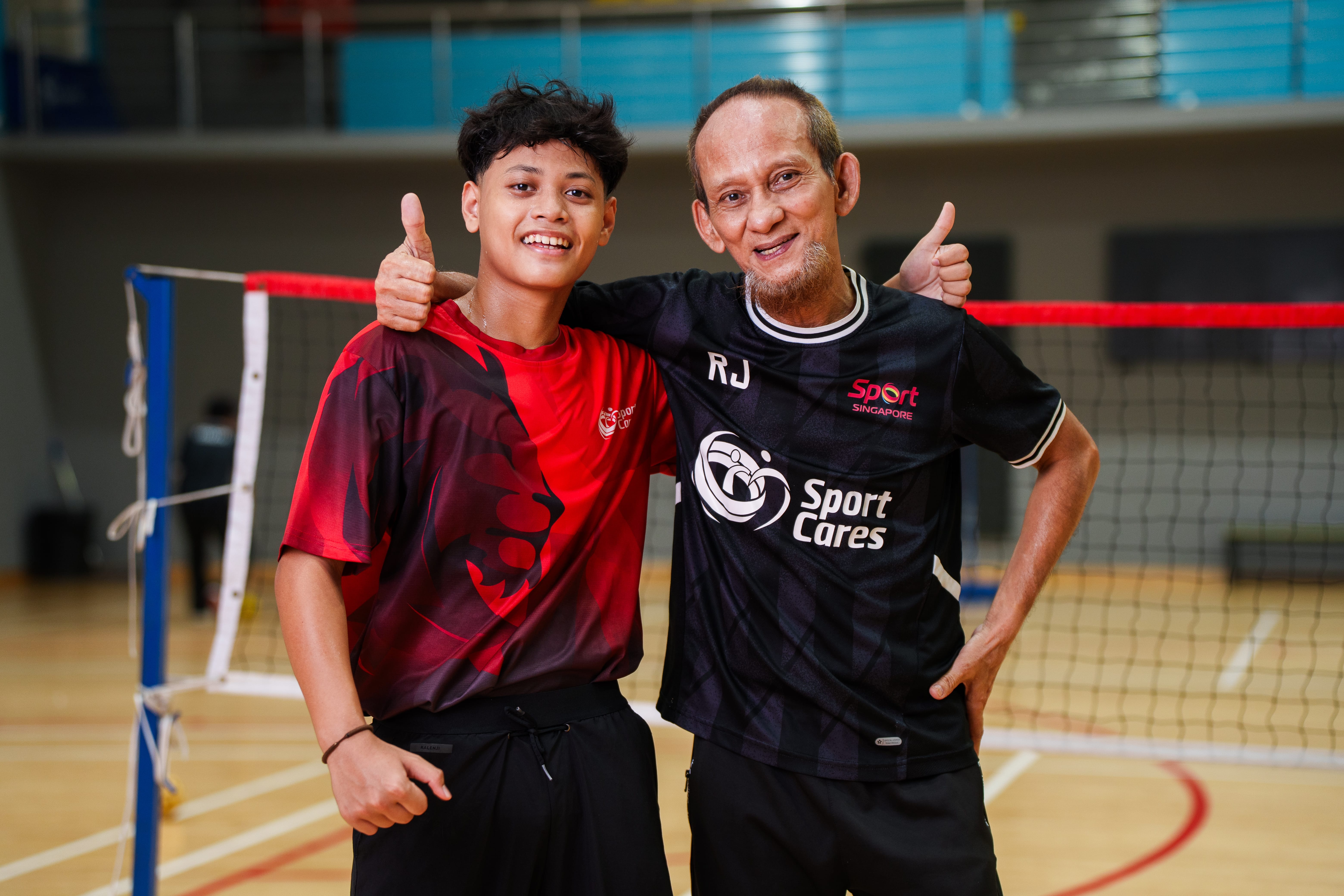 Irfan posing with a middle-aged man, both in sports attire, posing with their thumbs up.