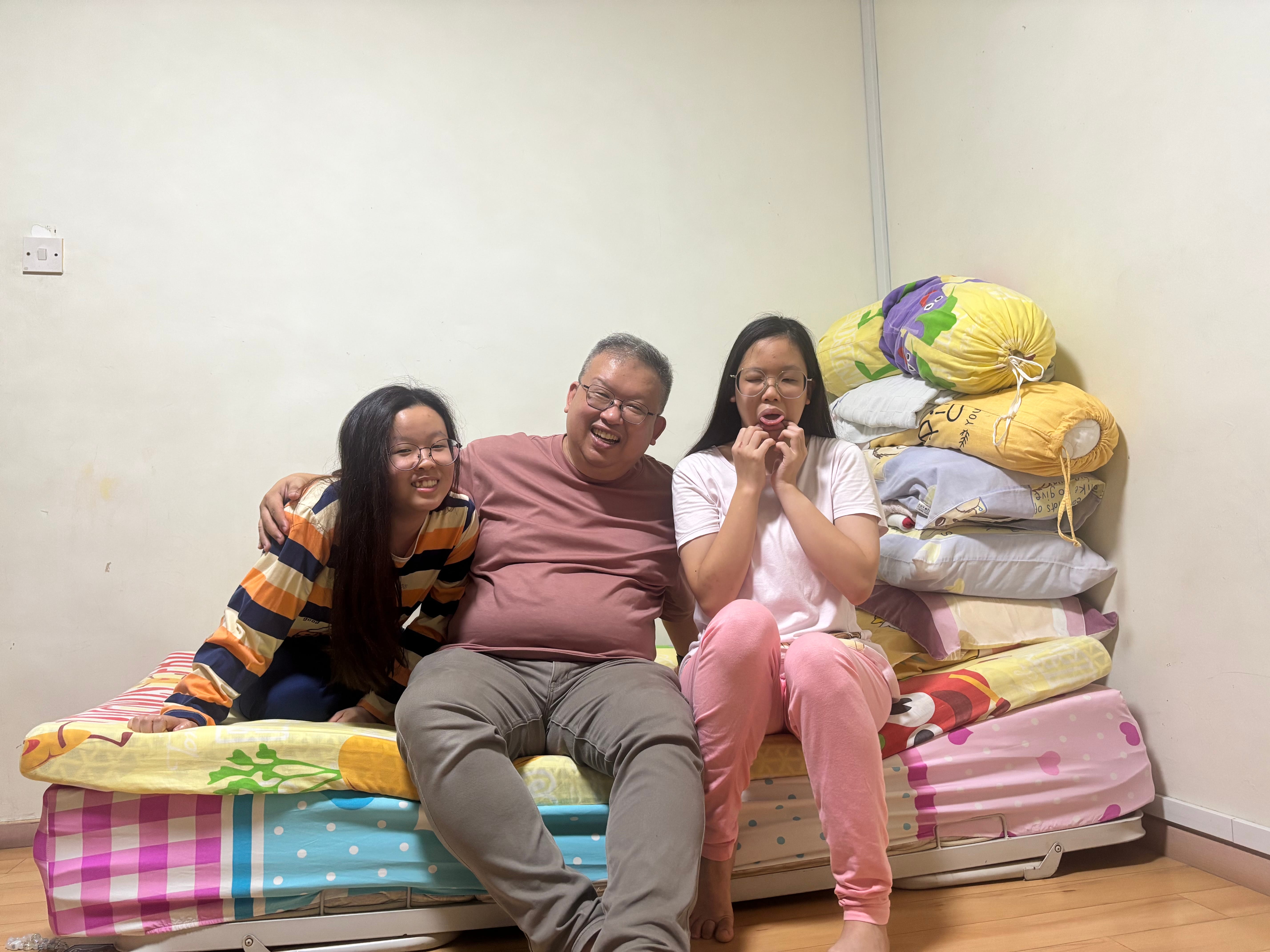 Father sitting down in between his two daughters