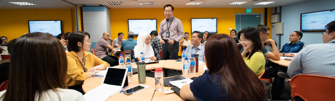 Officers and staff in a classroom setting engaged in group learning activity.