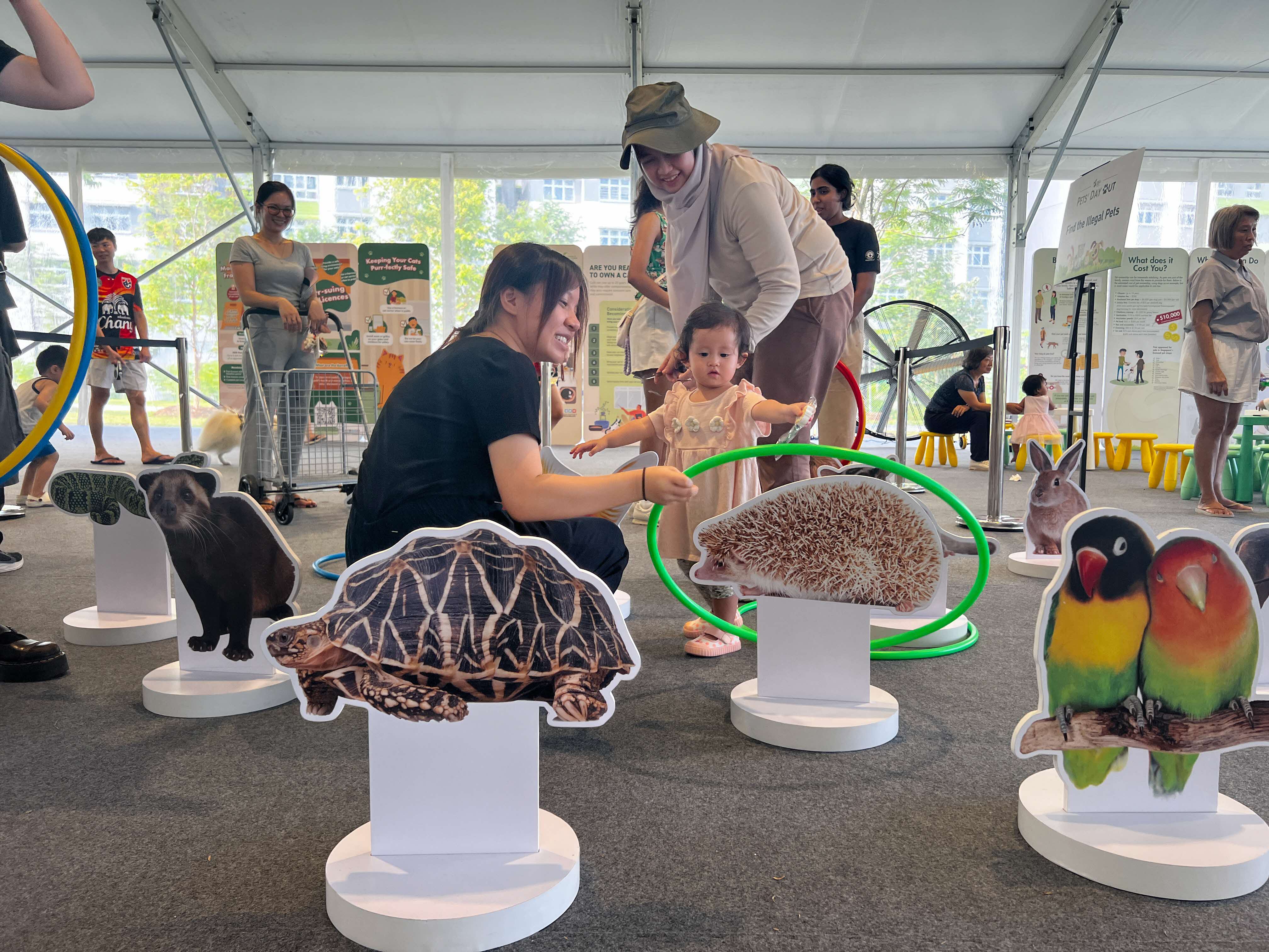 A photograph of a young child playing at a game booth
