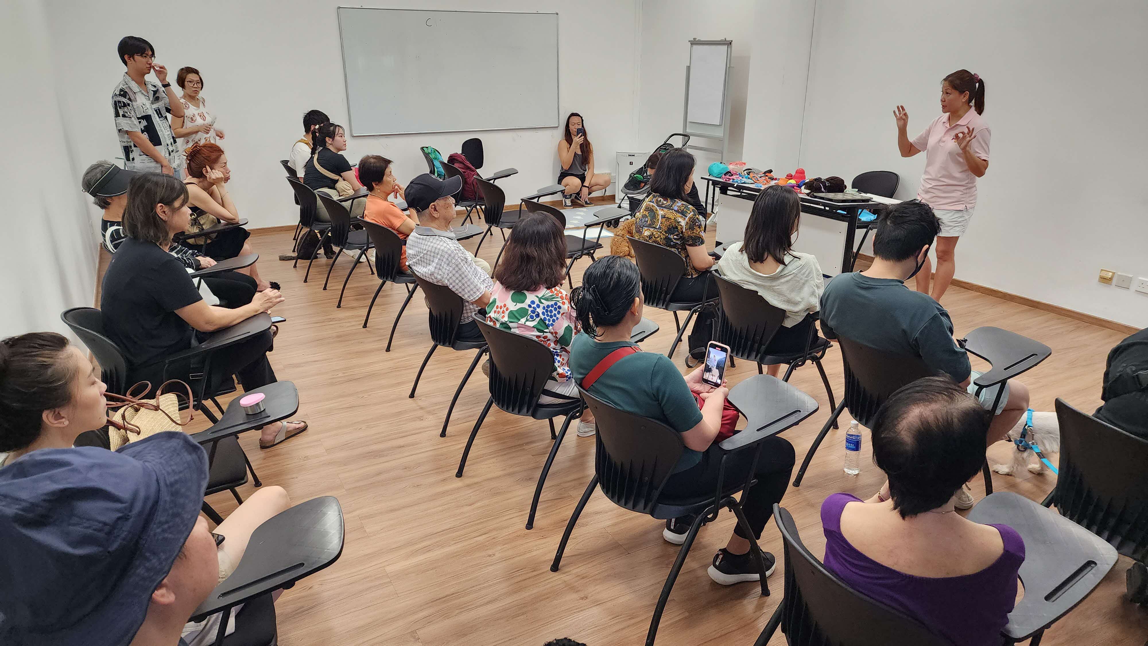 A photograph of a woman giving a seminar to an audience
