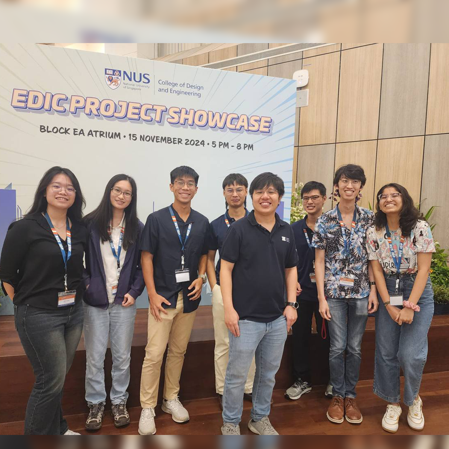 A group of people are standing in front of an "EDIC Project Showcase" sign at NUS College of Design and Engineering.