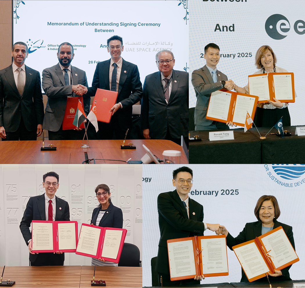 Five people in suits signing documents with red folders at a Memorandum of Understanding ceremony.