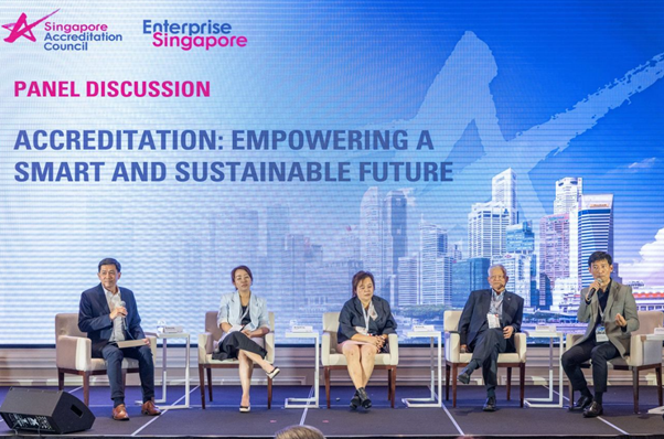 Five panelists seated on stage at a Singapore Accreditation Council panel discussion on accreditation and sustainability.