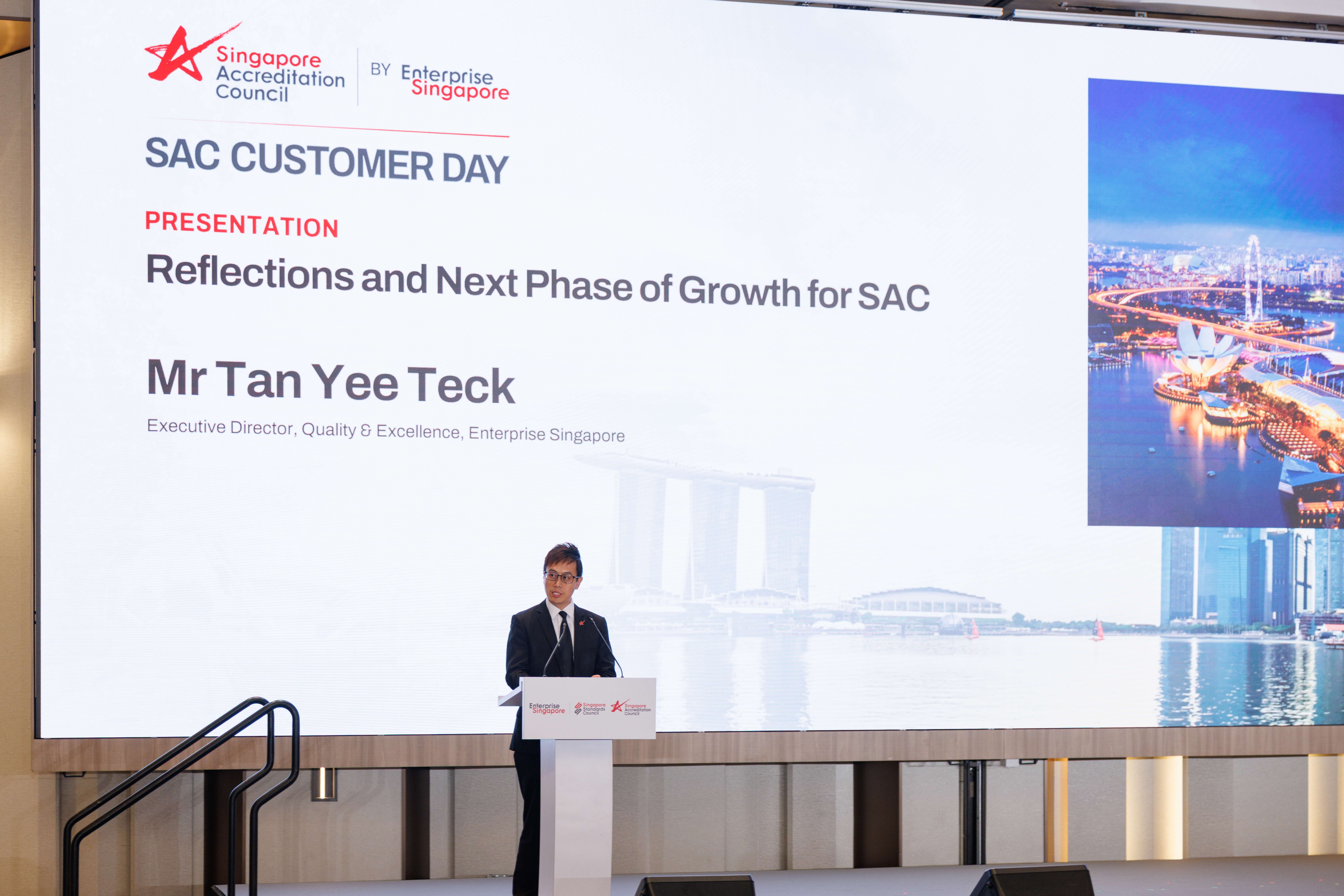 Man in a suit speaks at a podium during SAC Customer Day presentation by Mr Tan Yee Teck, Enterprise Singapore.