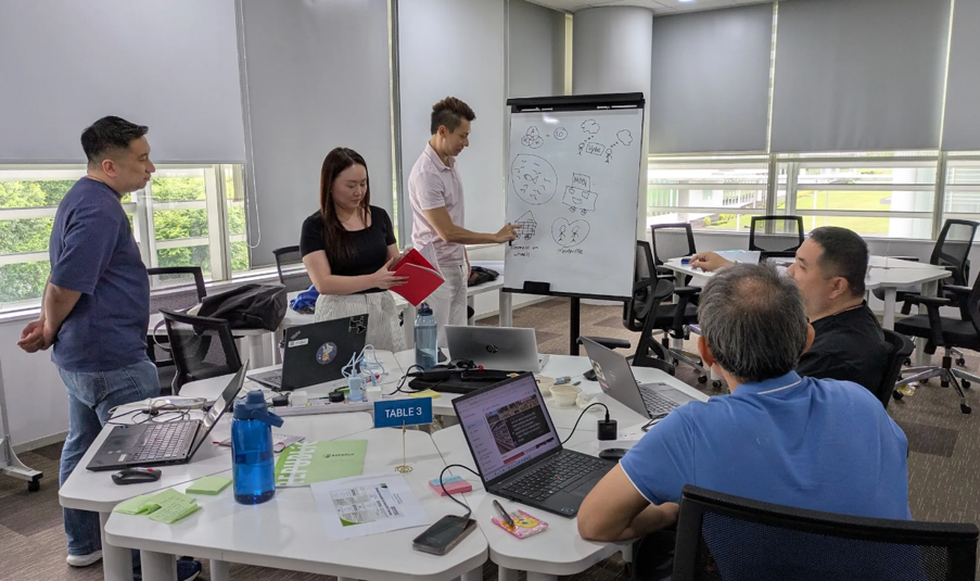 a group discussion with a man writing on a whiteboard.
