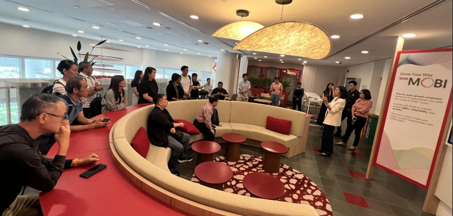 A group of participants sitting in the lounge listening to a speaker